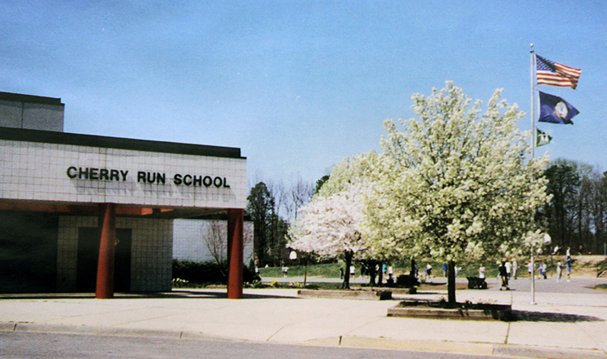 Photograph of the front of Cherry Run Elementary School. The cherry trees are fully grown and are in bloom.